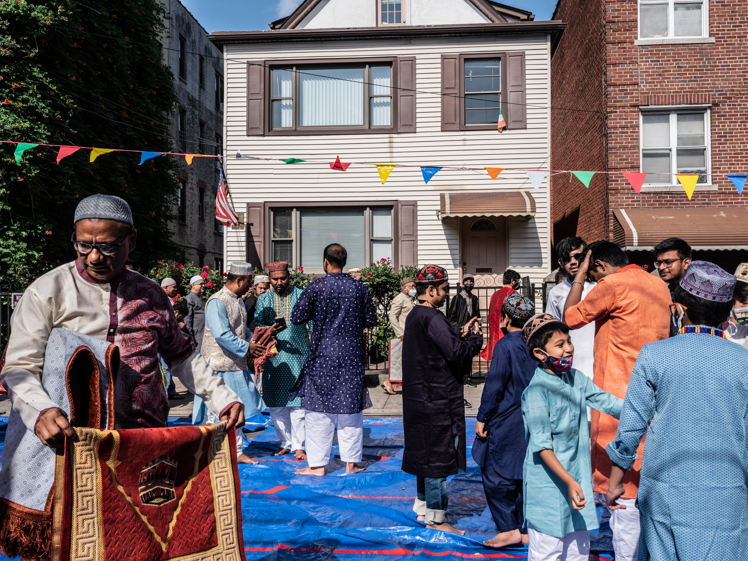 Bangladeshi men greet each other after finishing prayers for Eid al-Adha in Jackson Heights, Queens, on July 09, 2022.