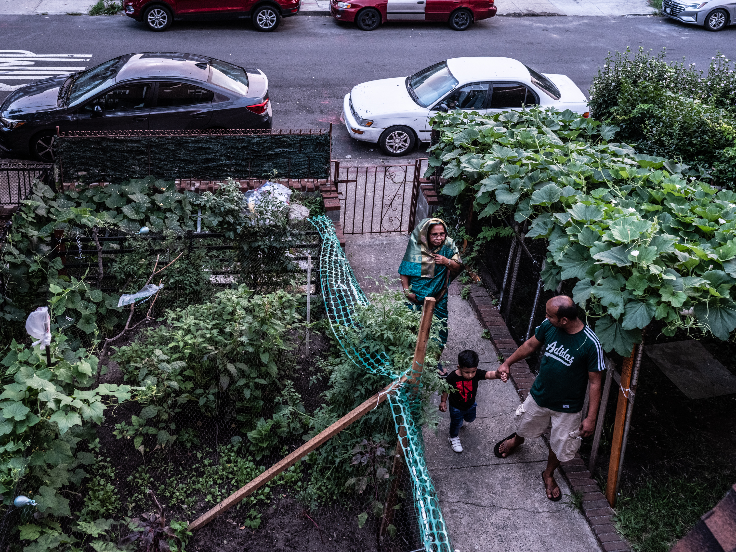 Onu takes his son Jaif and mother Aktar to his garden outside their apartment in Jackson Heights, Queens,