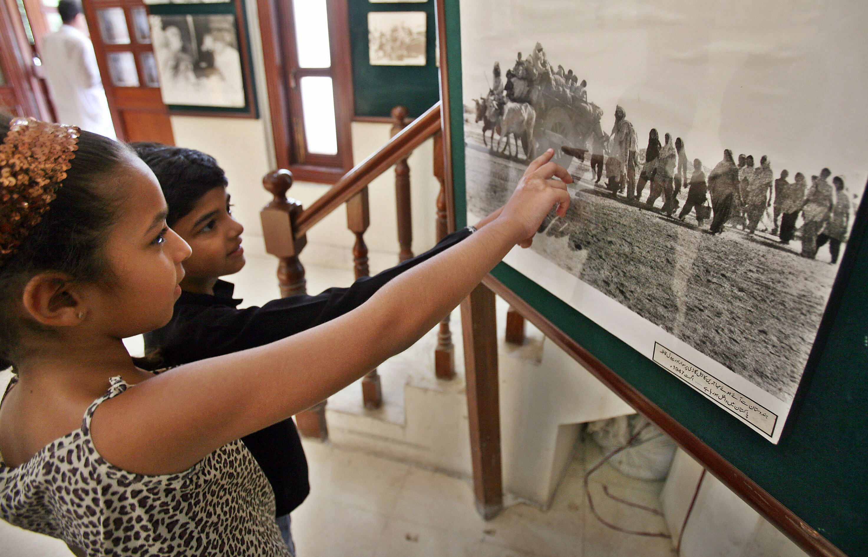 Pakistani children look at a photograph of the 1947 Pakistan-India partition at an exhibition in Lahore, 12 August 2007. 