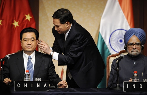 Chinese President Hu Jintao (L) is helped with his headphone next to Indian Prime Minister Manmohan Singh (R) at the G8 Summit meeting in Sapporo, Japan on July 8, 2008. (Jewel Samad/AFP/Getty Images)