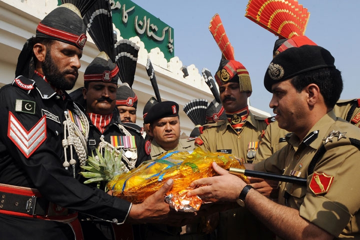 Indian Deputy Inspector General of Border Security Force (BSF) Mohammad Aquil (R) presents sweets to Pakistani Rangers personnel prior to a meeting at the Wagah Border Post, which marks the border between Pakistan and India, on Oct. 14, 2009. (Arif Ali/AFP/Getty Images)