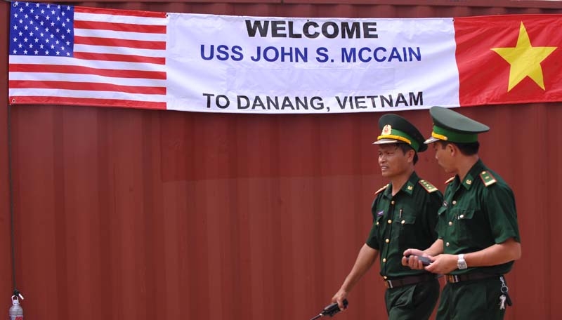 Two Vietnamese border-guard officers walk past a banner welcoming the port call by the US destroyer USS John S. McCain at Tien Sa port in the central costal city of Danang on August 10, 2010. (Hoang Dinh Nam/AFP/Getty Images) 
