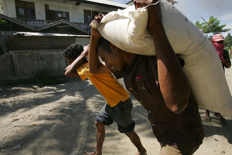 East Timorese residents of Dili haul bags of rice as they loot empty homes during political turmoil in Dili, East Timor, in 2006. (Paula Bronstein/Getty Images)