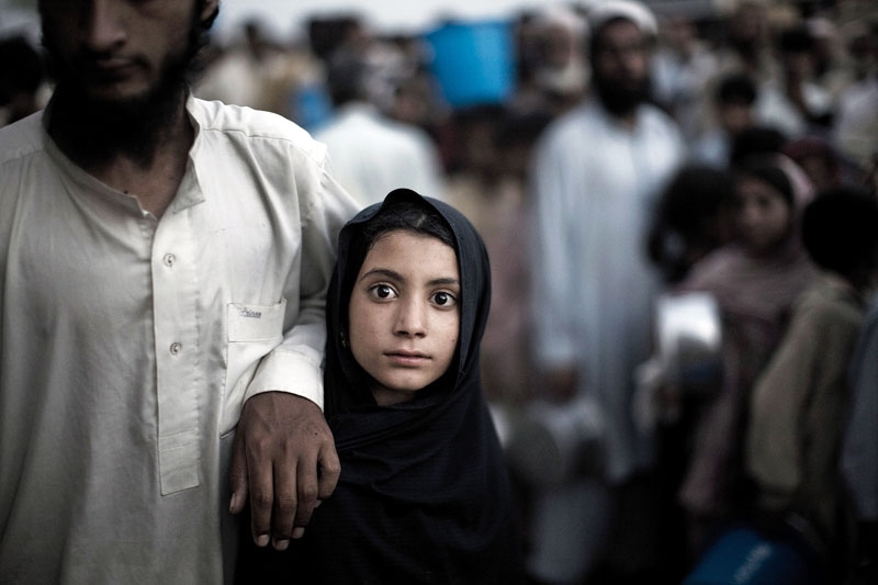 Displaced by the Pakistan Army's 2009 offensive against the Taliban in Swat, a young girl waits for food rations at the Chota Lahore relief camp in Swabi, Pakistan. (Daniel Berehulak/Getty Images)