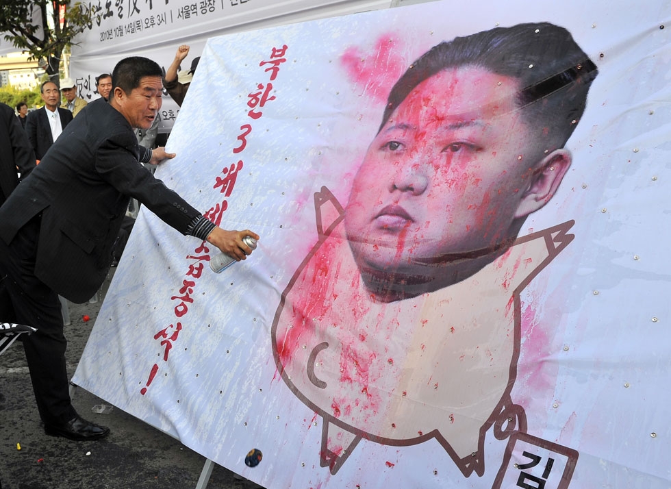 A South Korean activist paints on a caricature of Kim Jong Un, the youngest son and heir-apparent of North Korean leader Kim Jong Il, during a rally denouncing the communist country's third-generation dynastic succession in Seoul on October 14, 2010. (Jung Yeon-Je/AFP/Getty Images)