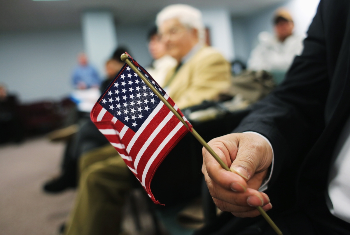 An immigrant from India holds a flag while waiting for a naturalization ceremony to become a U.S. citizen