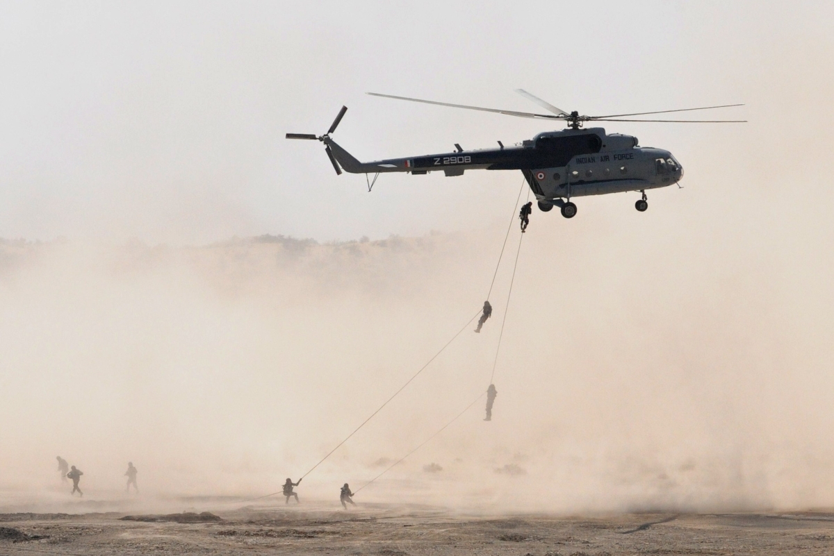 Indian and U.S. soldiers rappel from an Indian Air Force helicopter for military exercise