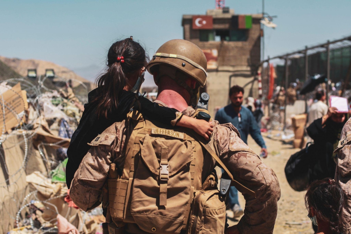 A United States Marine carries a child to be processed during an evacuation at Hamid Karzai International Airport in Kabul, Afghanistan, on August 25, 2021.