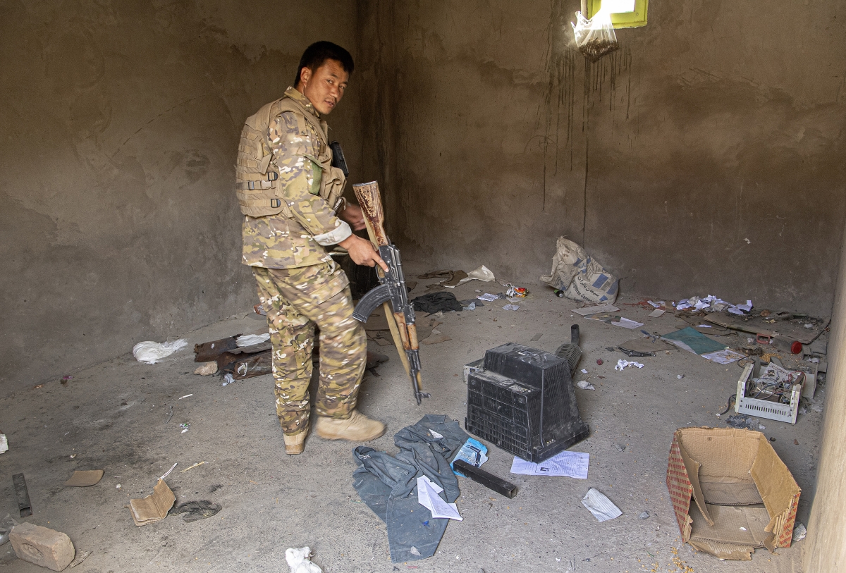 A Bamyan police soldier examines a room looted by Taliban forces at a police base in Ghandak village, Shibar district, Bamyan on Jul 18, 2021.