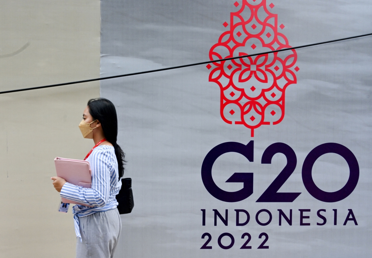 A woman walks past a logo of the G20 Summit, in Jakarta on November 8, 2022.