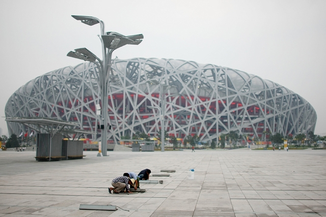 Workers adjust the Olympic Green pavement at the National Stadium before the Beijing Olympic Games on August 4, 2008. (Nick Laham/Getty Images)