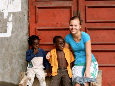 Student studying abroad, posing with children. (Miss Hibiscus / istockphoto)