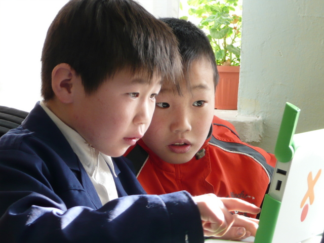 Students in Ulaanbaatar checking collaborating on an XO laptop. Photo: one laptop per child/flickr.com.