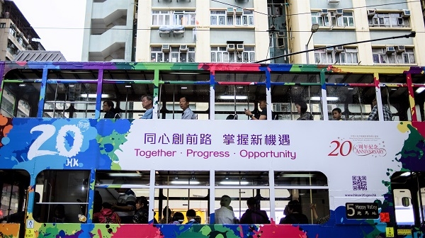 Commuters travel in a tram with a design commemorating the 20th anniversary since the city was handed back to China by colonial ruler Britain, in a residential neighborhood of Hong Kong (ANTHONY WALLACE/AFP/Getty Images).
