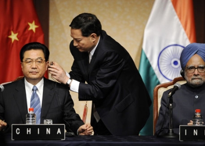 Chinese President Hu Jintao (L) is helped with his headphone next to Indian Prime Minister Manmohan Singh (R) at the G8 Summit meeting in Sapporo, Japan on July 8, 2008. (Jewel Samad/AFP/Getty Images)