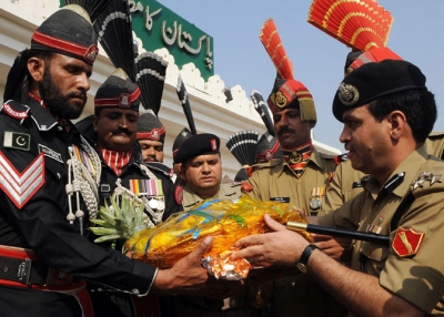 Indian Deputy Inspector General of Border Security Force (BSF) Mohammad Aquil (R) presents sweets to Pakistani Rangers personnel prior to a meeting at the Wagah Border Post, which marks the border between Pakistan and India, on Oct. 14, 2009. (Arif Ali/AFP/Getty Images)