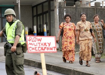 Women walk past an army checkpoint in central Suva on December 7, 2006, days after a military coup in Fiji. (William West/AFP/Getty Images) 