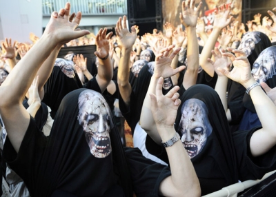 Movie fans wearing zombie printed T-shirts over their heads in Tokyo