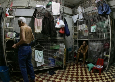 Mr Kong (R) a cage dweller sits in a cage on June 20, 2007 in Hong Kong, China. The poorest of Hong Kong's citizens live in cage homes, steel mesh box constructions, stacked on top of each other. (MN Chan/Getty Images)