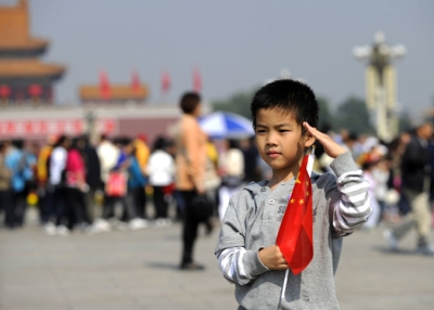 A boy poses for pictures on Tiananmen Square in Beijing on September 30, 2010, on the eve of China's National Day.