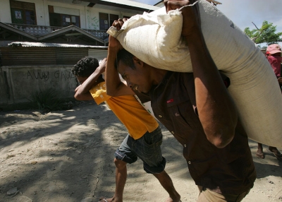 East Timorese residents of Dili haul bags of rice as they loot empty homes during political turmoil in Dili, East Timor, in 2006. (Paula Bronstein/Getty Images)