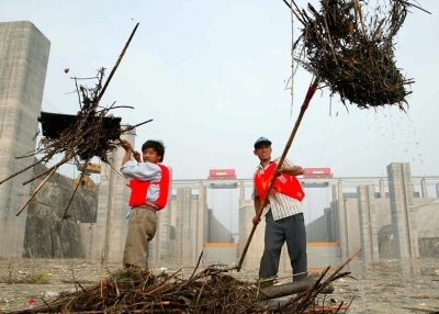 Workers clear heaps of trash outside the sluice gates at the Three Gorges dam near Yichang in central China's Hubei province on June 10, 2003. (AFP/Getty Images)