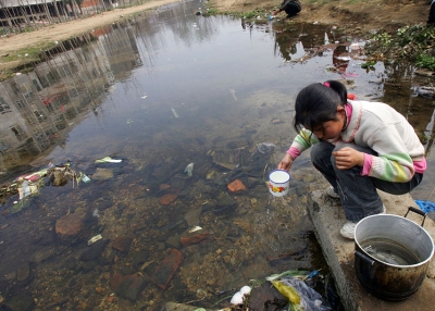 A girl collects water from a ditch in Hubei Province, China, in Mar. 2008. In China, an estimated 300 million rural residents still have low access to safe drinking water, and 400 cities face water shortages. (China Photos/Getty Images)