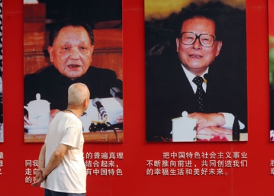 An elderly man looks at portraits of former Chinese communist leaders (L to R) Mao Zedong, Deng Xiaoping, Jiang Zemin and current president Hu Jintao in Ditan Park in Beijing on June 28, 2011. (Peter Parks/AFP/Getty Images)