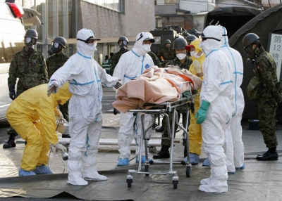 Real-life persons of the year? Rescue workers carry someone believed to be contaminated with radiation to a treatment center in Nihonmatsu city in Japan's Fukushima prefecture on Mar. 13, 2011. (Jiji Press/AFP/Getty Images) 