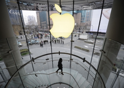 A customer walks under an Apple logo sign at an Apple shop in Shanghai on February 22, 2012. (Peter Parks/AFP/Getty Images)