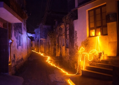 A string of LED lights designed for the Harvestival by Taiwanese architect Teng Hai lit the alleyways of Bishan, providing the village with its first street light. The light remained on for three days before it was ordered turned off. (Leah Thompson)