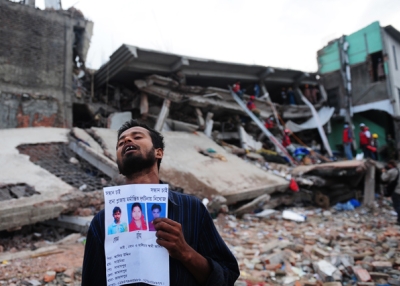 A Bangladeshi man holds a portrait of his missing relatives, believed trapped in the rubble of an eight-storey building that collapsed in Savar, on the outskirts of Dhaka, Bangladesh on April 28, 2013. (Munir Uz Zaman/AFP/Getty Images)