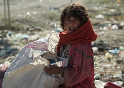 A young nomad girl looks on as she searches amongst the garbage for iron and plastic items to sell in Ghazni, Afghanistan on May 28, 2013. (Rahmatullah Alizada/AFP/Getty Images)