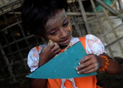 A child of the Rohingya minority group applies a traditional cosmetic paste at an IDP camp in Sittwe, Myanmar on May 18, 2013. (Soe Than Win/AFP/Getty Images)
