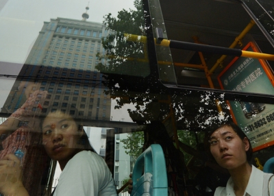 Commuters look at the Intermediate People's Court — where Bo Xilai was indicted and his case is expected to be heard — reflected in a bus window in Jinan, Shandong province on July 25, 2013. (Mark Ralston/AFP/Getty Images)