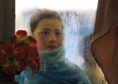 Kabul, 2002: Switan, age ten, looks into the window of the Herat restaurant. She gazes at people eating with the hopes of getting leftovers and makes 50,000 to 70,000 Afghani ($2.50 U.S.) per day begging from foreigners. (Paula Bronstein/Getty Images)