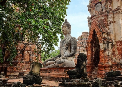 Broken statues and red ruin walls surround a giant Buddha statue in Ayutthaya, Thailand on October 4, 2013. (C. Reid Taylor/Flickr)