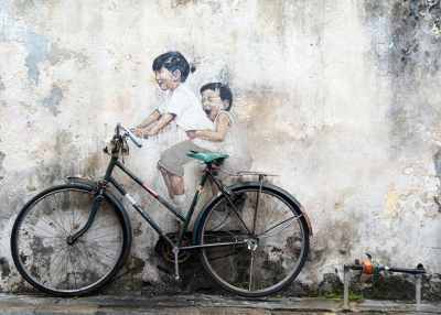 A bike rests against a famous art mural by Ernest Zacharevic in Georgetown, Penang, Malaysia on December 1, 2013. (Etienne Girardet/Flickr)