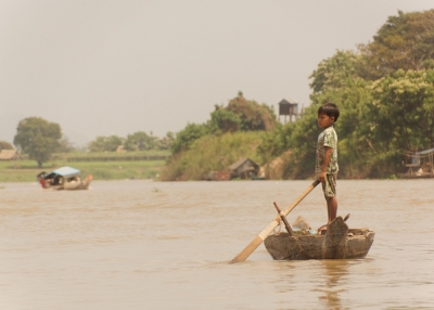 A young boy drifts on a boat all alone in Kampong Chhang, Cambodia on February 24, 2014. (Suivez-Nous . Asia/Flickr)