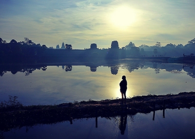 A slim figure is silhouetted by the sun at Angkor Wat in Siem Riep, Cambodia on March 27, 2015. (Roberto Trm/Flickr)
