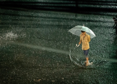 A young boy walks through a flooded street during a downpour in Phnom Penh, Cambodia on April 23, 2015. (Ariel Leuenberger/Flickr)