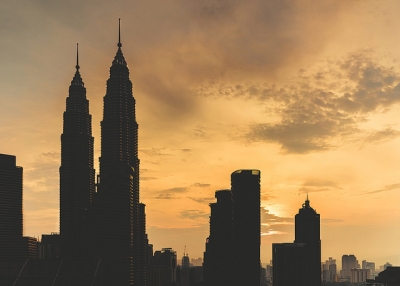 As the sun sets over the city, silhouettes of the Petronas Towers dominate the skyline in Kuala Lumpur, Malaysia on July 27, 2015. (Rob M/Flickr)