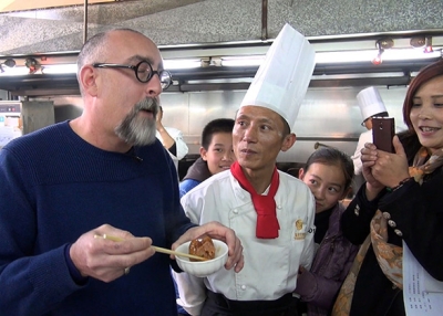 Howie Southworth slurps pork trotters with Chef Yang Jiaquan at the Qianhe Hotel in Qilin, Yunnan, China. (Howie Southworth)