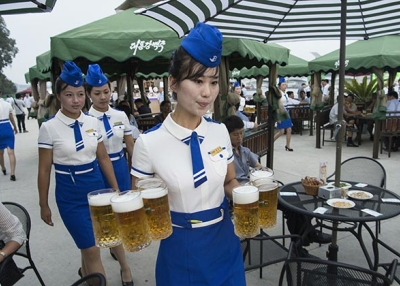 A waitress carries jugs of beer to guests before the opening of the Pyongyang Taedonggang Beer Festival on the banks of the Taedong river in Pyongyang on August 12, 2016. (Kim Won-jin/AFP/Getty)