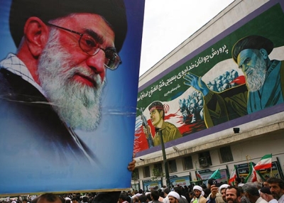 A pro-government demonstrator holds aloft a picture of Ayatollah Ali Khamenei at Tehran University. (Getty)