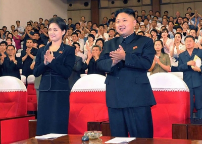 North Korean leader Kim Jong Un (C), accompanied by a young woman later confirmed as his wife Ri Sol-Ju (L), enjoying a performance by the newly organized Moranbong band in Pyongyang on July 6, 2012. (KNS/AFP/GettyImages) 