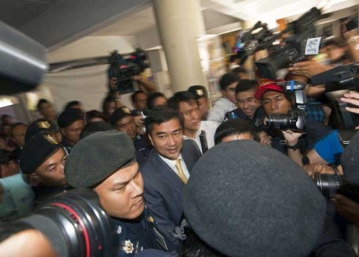 Former Thai prime minister Abhisit Vejjajiva (C) arrives at the Bangkok Metropolitan Police headquarters on Dec. 9, 2011 for questioning over a deadly military crackdown he oversaw on mass opposition protests in Bangkok in April and May of 2010. (Joan Manuel Baliellas/AFP/Getty Images) 