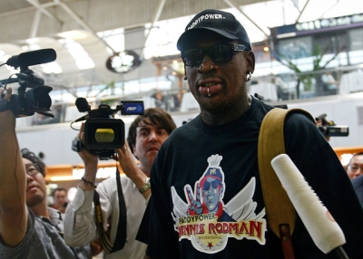 Former NBA basketball player Dennis Rodman is surrounded by members of the media as he makes his way through Beijing's international airport on September 3, 2013. Rodman said he was heading back to Pyongyang to see his "friend," North Korean leader Kim Jong Un, but refused to say if he would come back with an imprisoned US citizen. (Wang Zhao/AFP/Getty Images)