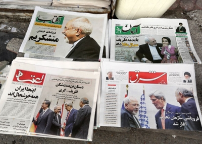 Iranian newspapers headlining the deal made with major powers over Iran's nuclear program are displayed outside a Tehran kiosk on Nov. 25, 2013. Most Iranian newspapers hailed the deal, attributing its relatively swift success to Foreign Minister Mohammad Javad Zarif (top left). (Atta Kenare/AFP/Getty Images) 