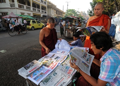 Buddhist monks read newspapers at a stall near the Shwedagon pagoda in Yangon on May 9, 2014. (Soe Than WIN/AFP/Getty Images)